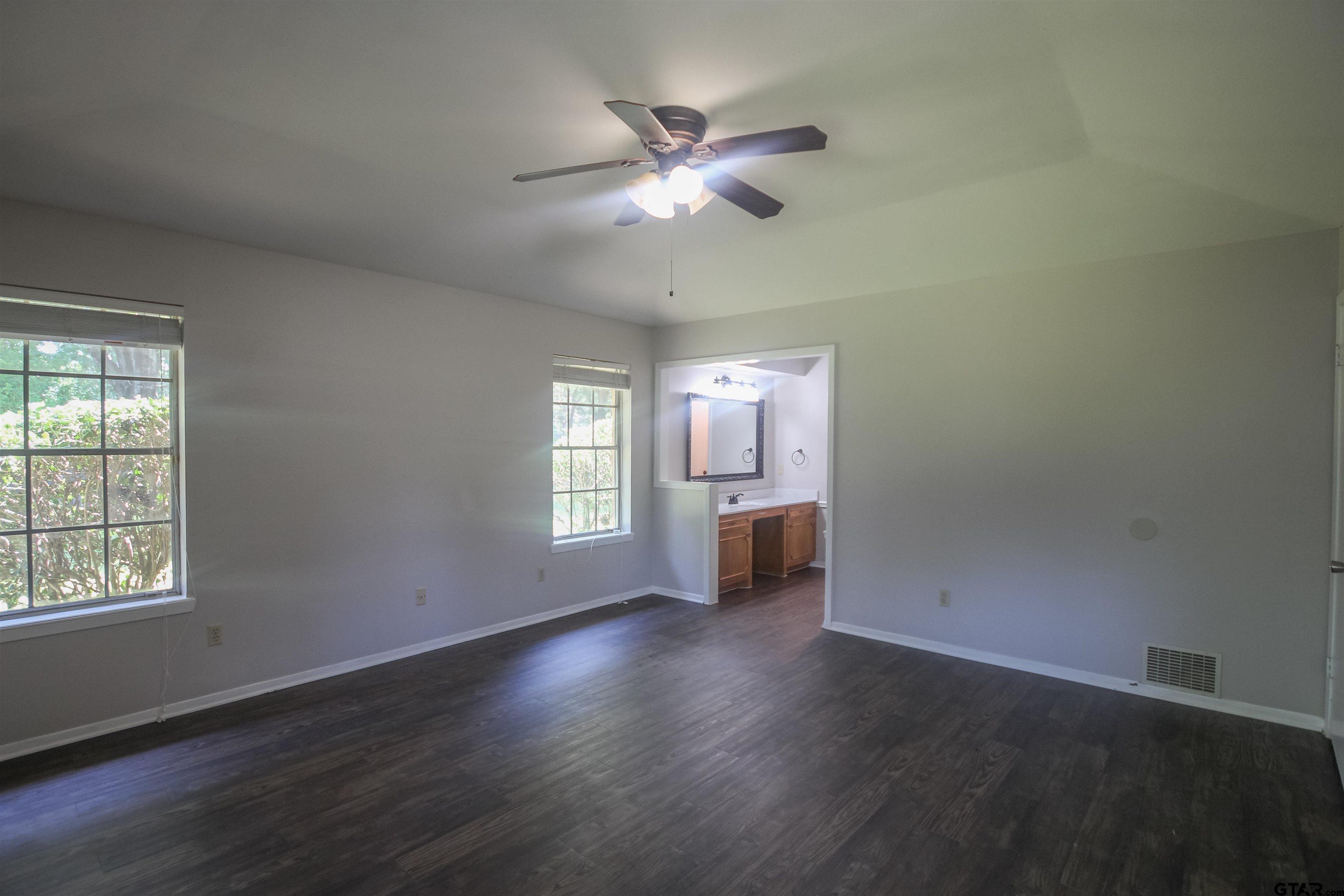 8524 Radcliffe Drive Tyler, TX 75703 - Photo 13 of 26 a view of an empty room with a window and wooden floor