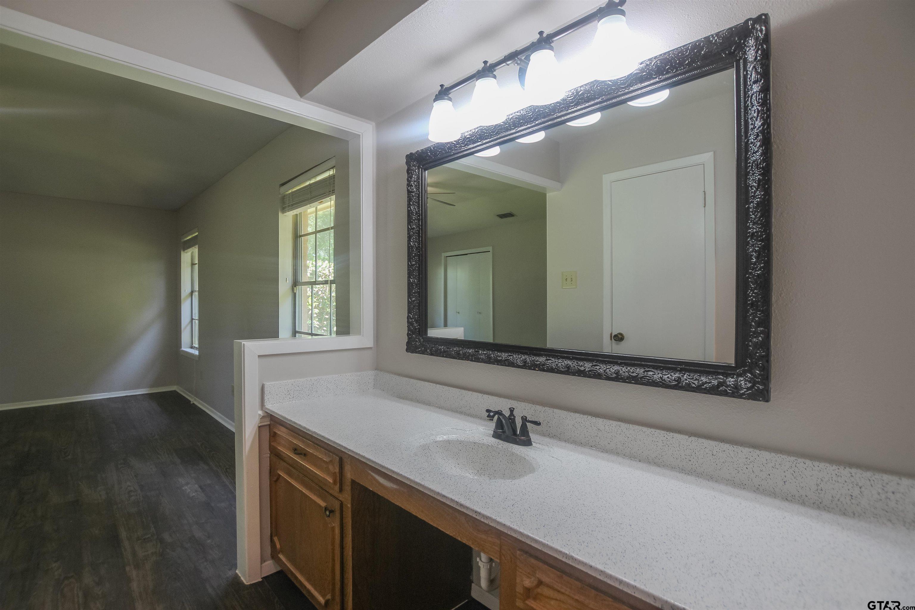 8524 Radcliffe Drive Tyler, TX 75703 - Photo 16 of 26 a bathroom with a sink and a mirror