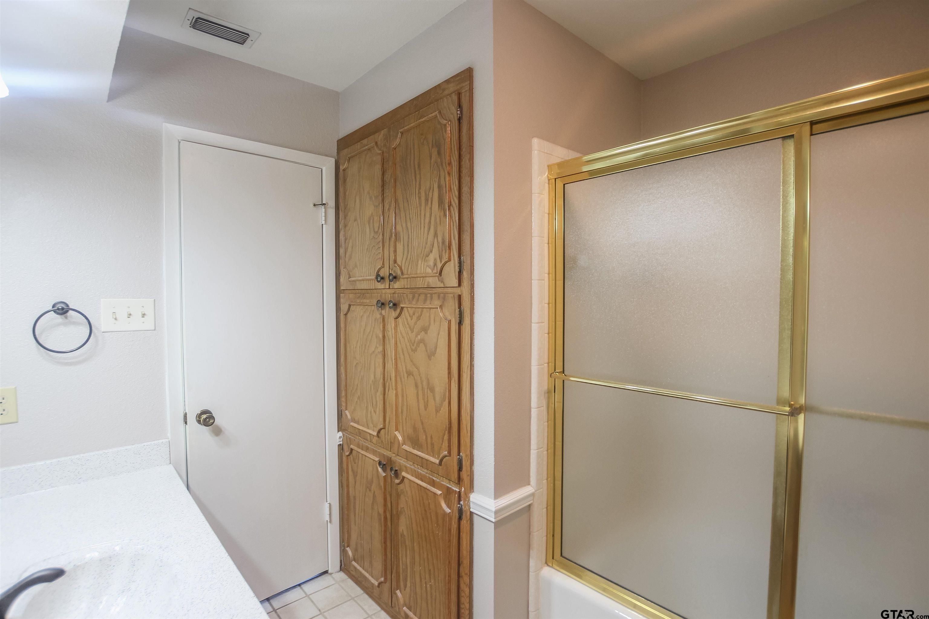 8524 Radcliffe Drive Tyler, TX 75703 - Photo 21 of 26 a bathroom with a glass shower door
