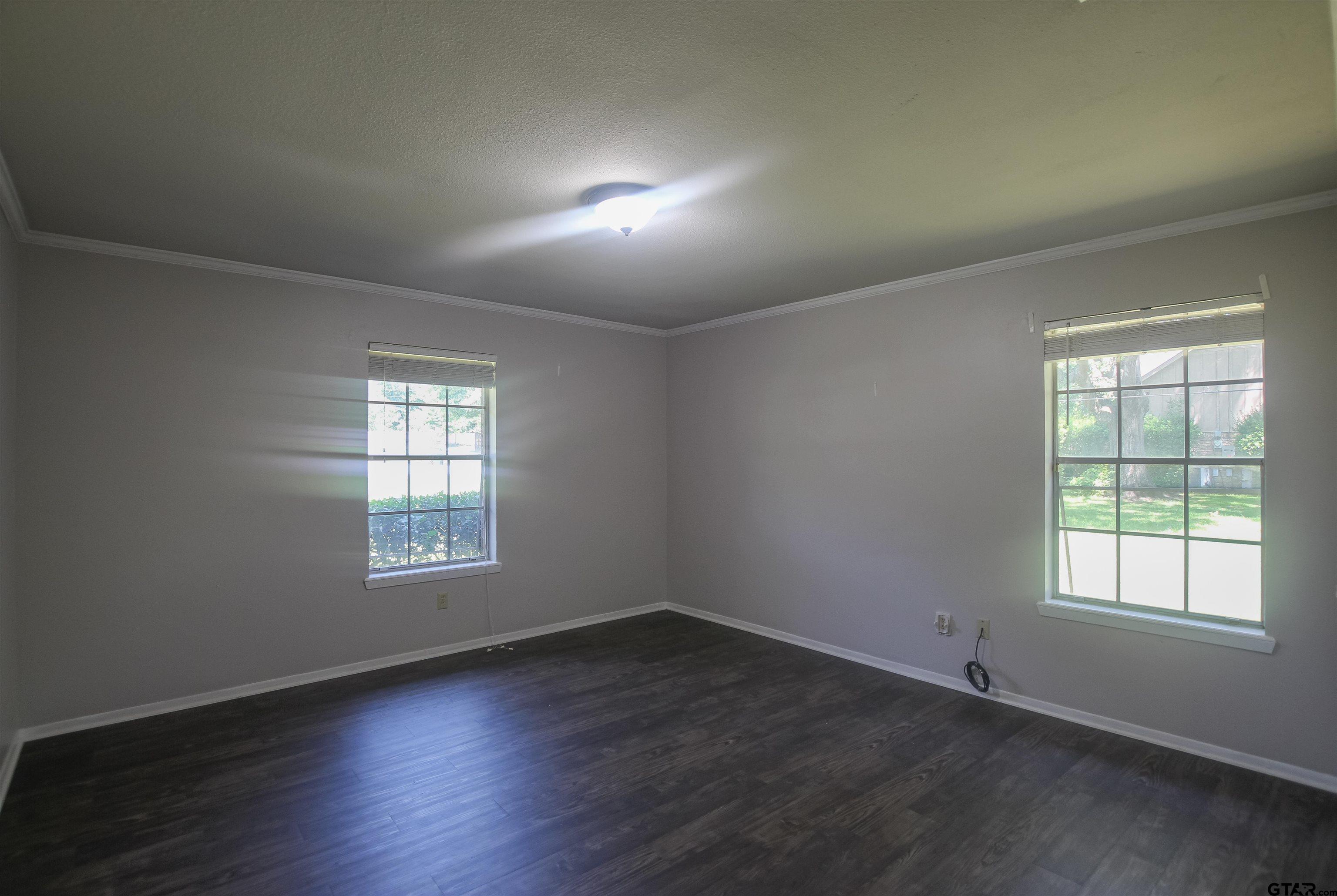 8524 Radcliffe Drive Tyler, TX 75703 - Photo 22 of 26 an empty room with wooden floor and windows