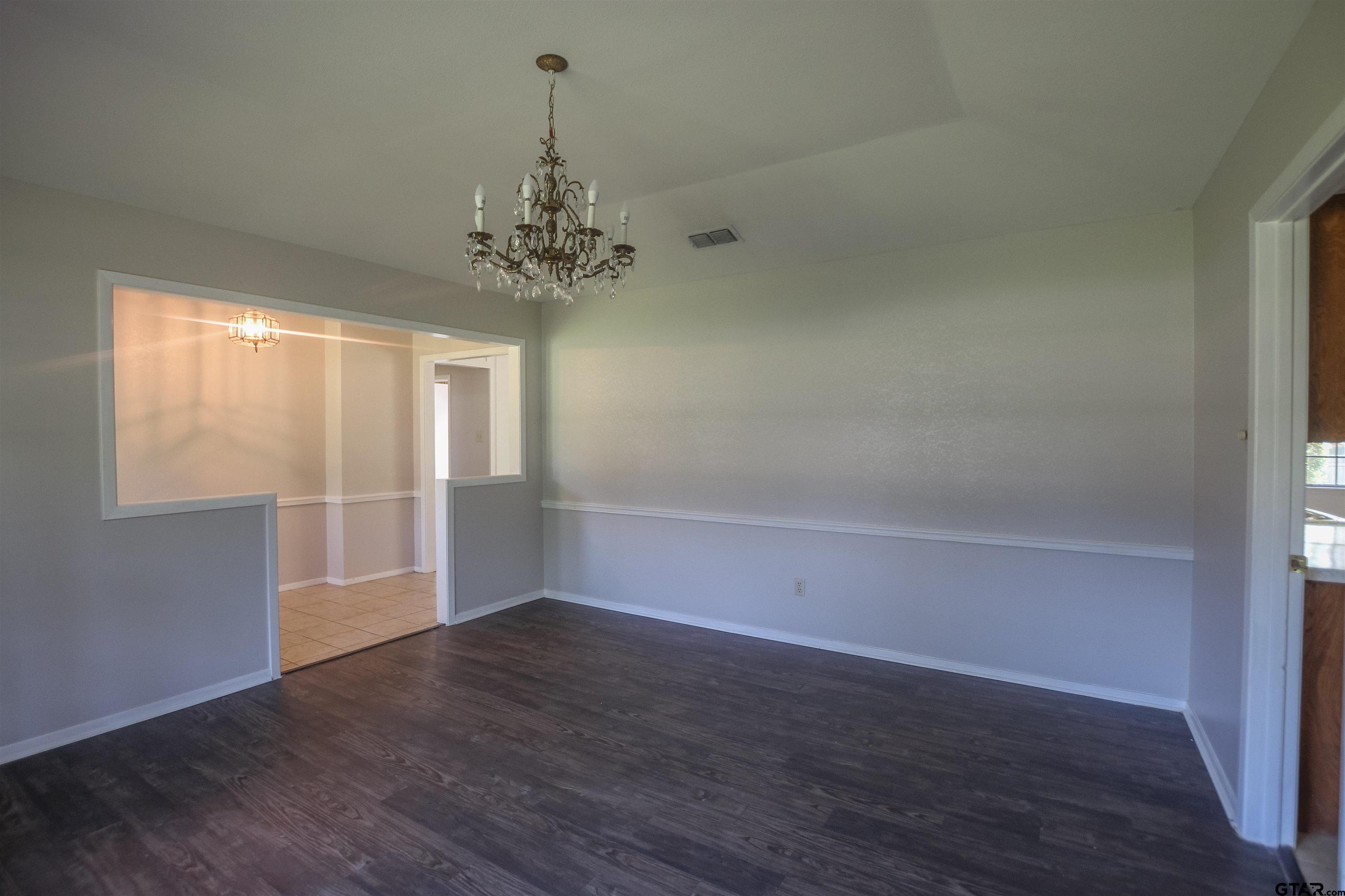 8524 Radcliffe Drive Tyler, TX 75703 - Photo 6 of 26 an empty room with wooden floor and windows