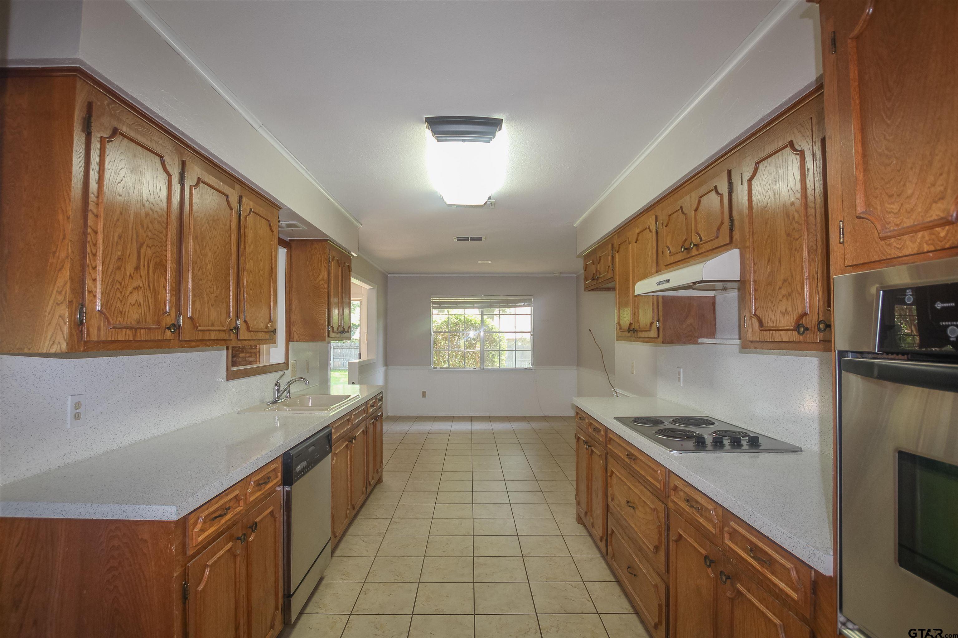 8524 Radcliffe Drive Tyler, TX 75703 - Photo 7 of 26 a large kitchen with a large window and stainless steel appliances