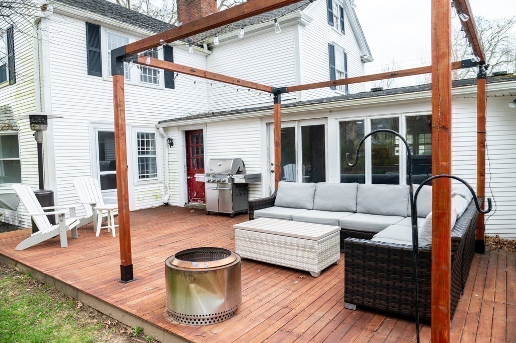 167 Elm Street Hanover, MA 02339 - Photo 19 of 26 a view of a patio with couches chairs dining table and chairs with wooden floor