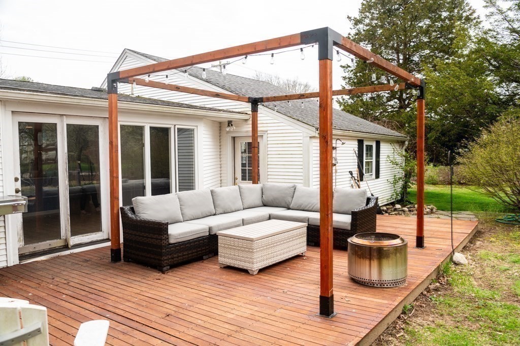 167 Elm Street Hanover, MA 02339 - Photo 20 of 26 a view of a patio with couches table and chairs with wooden floor and fence