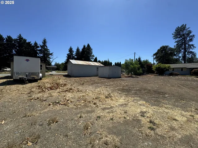 a view of a dry yard with wooden fence