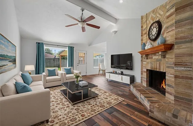 a living room with furniture a flat screen tv and a fireplace