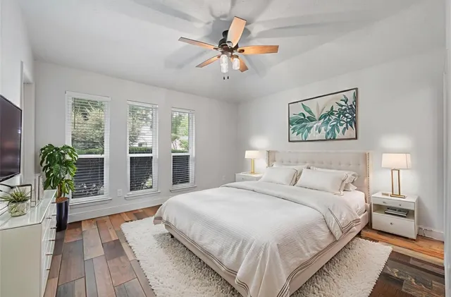 a bedroom with a large bed potted plant and a large window