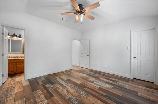 a view of empty room with wooden floor and ceiling fan