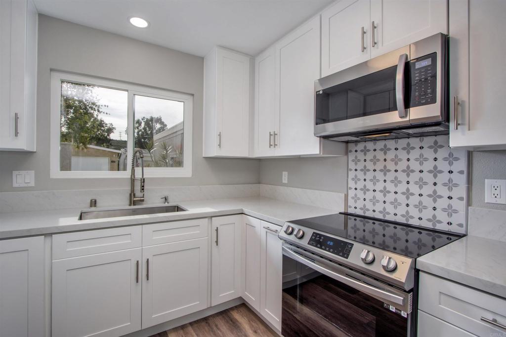 3824 Cinnamon Way Oceanside, CA 92057 - Photo 1 of 1 a kitchen with stainless steel appliances a sink stove and microwave