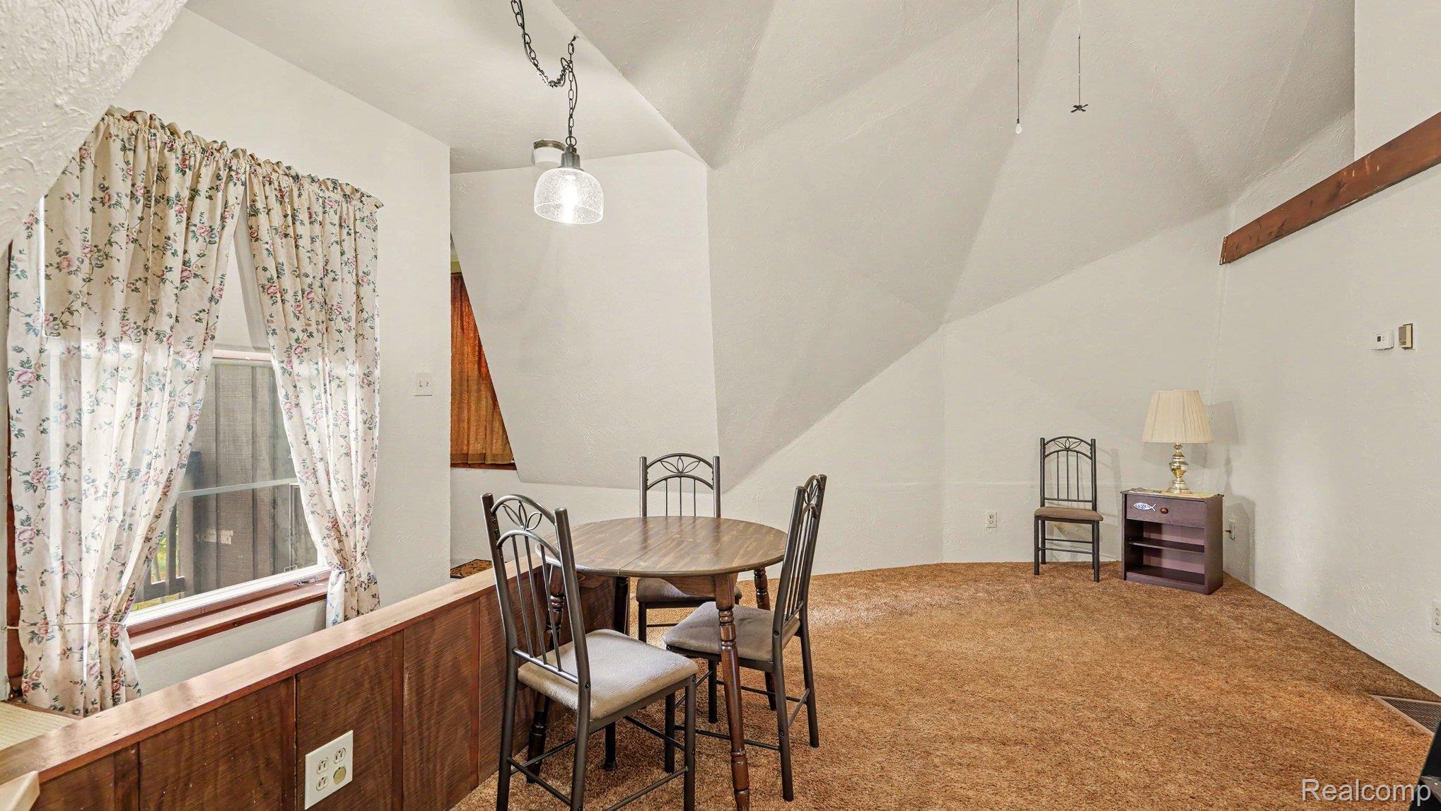 3700 Elbow Lake Road Prescott, MI 48756 - Photo 7 of 29 Vaulted ceiling with exposed beam, clear glass pendant light, and paneled wall accent