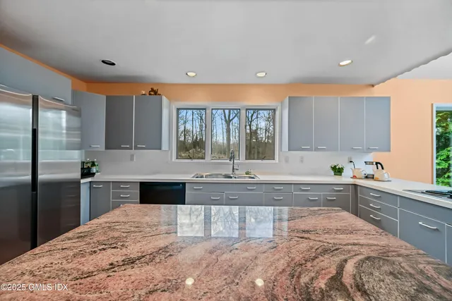 a kitchen with stainless steel appliances granite countertop a sink stove and refrigerator