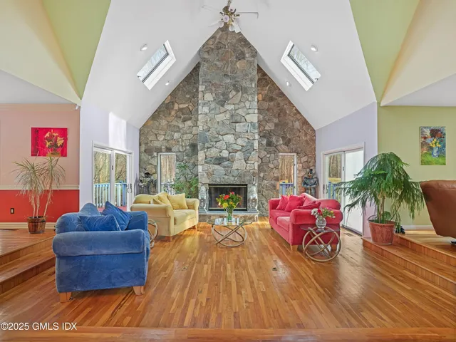 a living room with furniture a fireplace and a floor to ceiling window