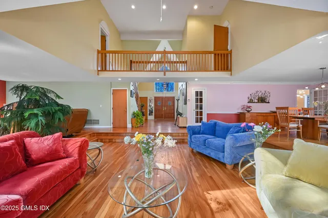 a living room with furniture floor to ceiling window and a flat screen tv