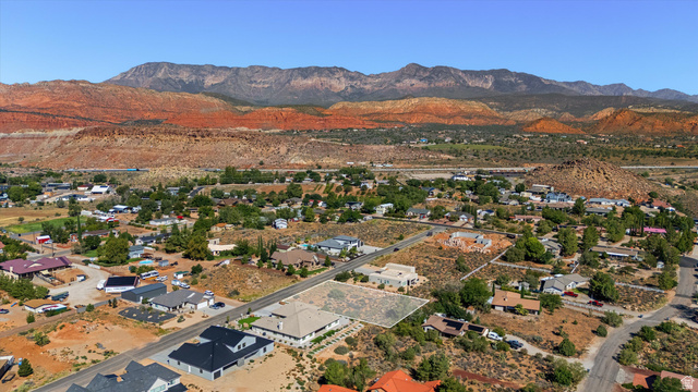 Expansive desert landscape with clear blue skies and distant red rock mountains