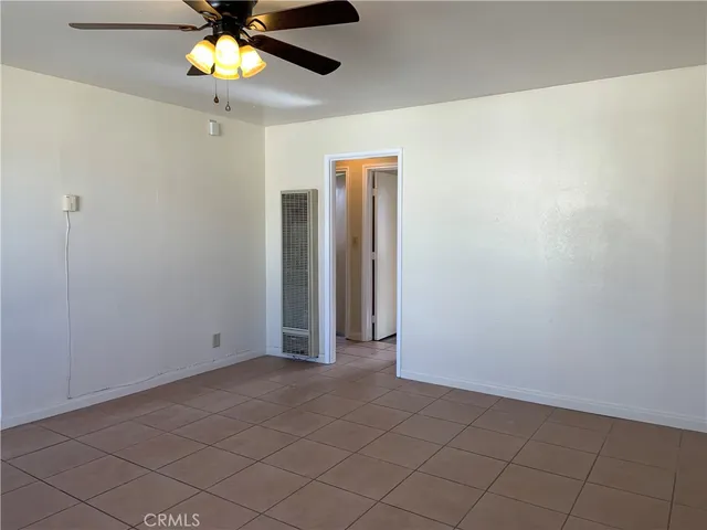 an empty room with a ceiling fan and a shower