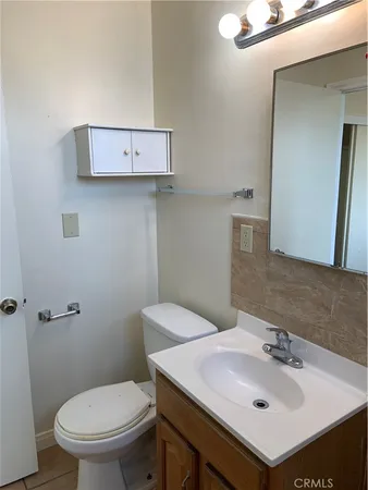 a bathroom with a sink toilet and mirror
