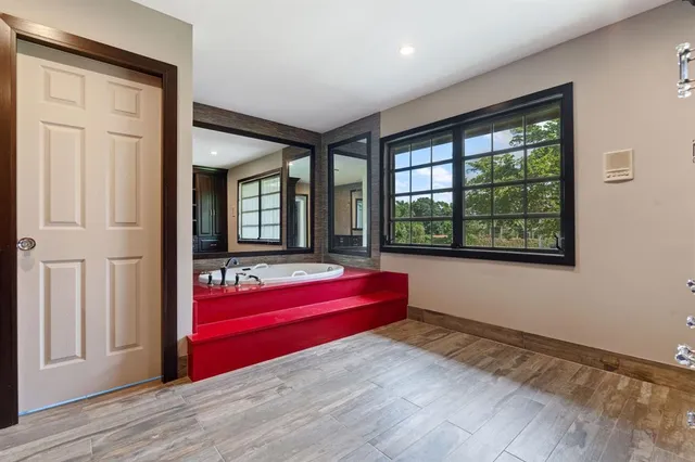 a bedroom with a bed a tv and wooden floor