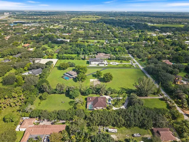 an aerial view of residential houses with outdoor space and swimming pool