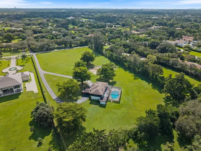 an aerial view of a house with a garden and lake view