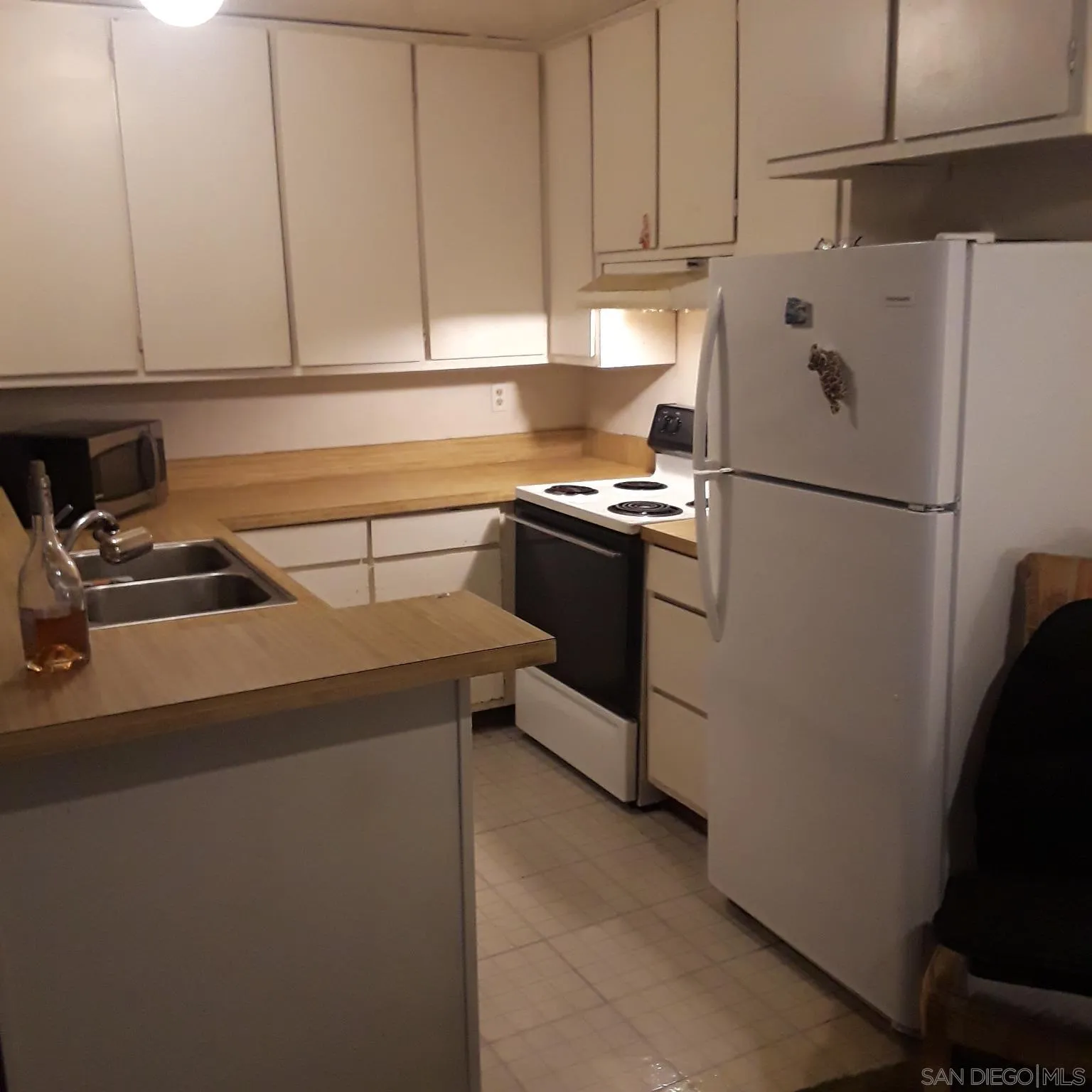 3550 Ruffin Road, Unit 233 San Diego, CA 92123 - Photo 7 of 17 a kitchen with a refrigerator sink stove and cabinets