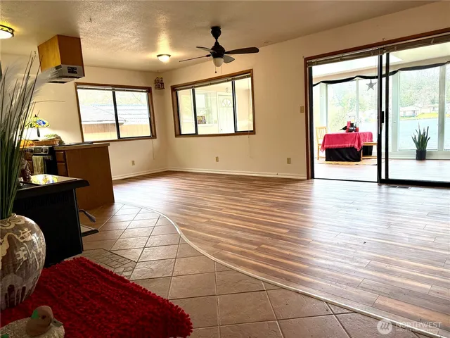 a view of an empty room with window and wooden floor