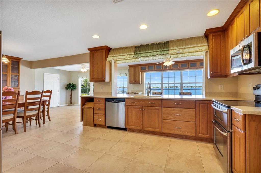 719 Southeast Riverside Drive Stuart, FL 34994 - Photo 5 of 17 a large kitchen with lots of counter and chairs