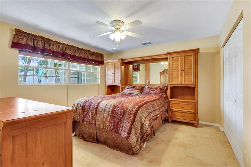 719 Southeast Riverside Drive Stuart, FL 34994 - Photo 10 of 17 a bed sitting in a spacious bedroom next to a window