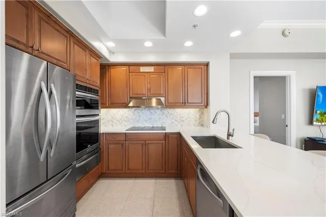 a kitchen with stainless steel appliances granite countertop a sink stove and refrigerator