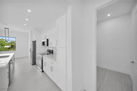 a kitchen with white cabinets and refrigerator