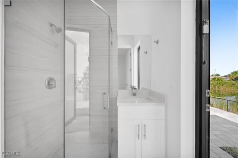 a bathroom with a granite countertop sink a mirror and shower