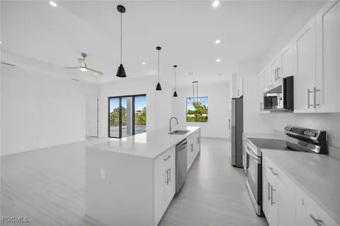 a kitchen with stainless steel appliances granite countertop a sink stove and refrigerator