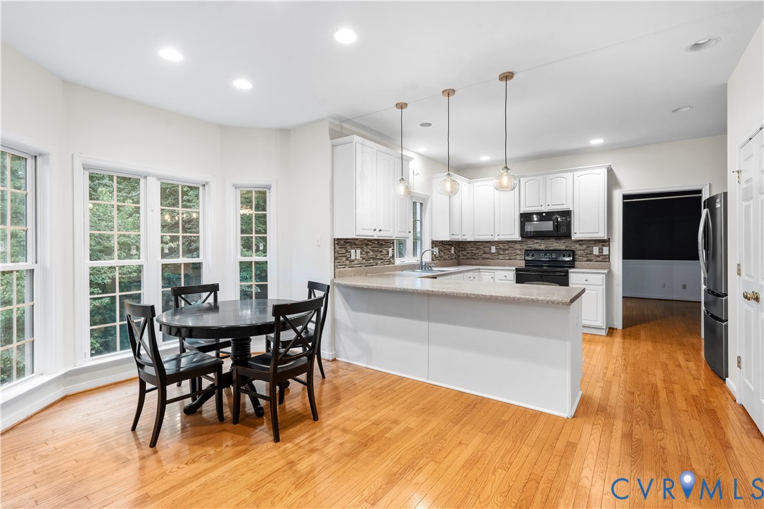 1301 Hawkins Wood Circle Midlothian, VA 23114 - Photo 13 of 50 a kitchen with stainless steel appliances a dining table chairs stove and refrigerator