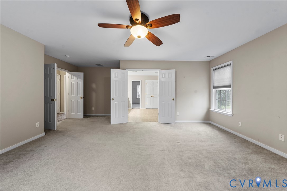 1301 Hawkins Wood Circle Midlothian, VA 23114 - Photo 28 of 50 an empty room with chandelier fan and windows