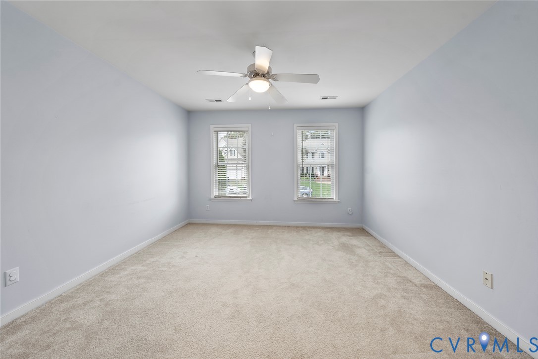 1301 Hawkins Wood Circle Midlothian, VA 23114 - Photo 33 of 50 an empty room with chandelier fan and windows