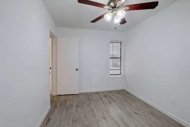 an empty room with a window and wooden floor