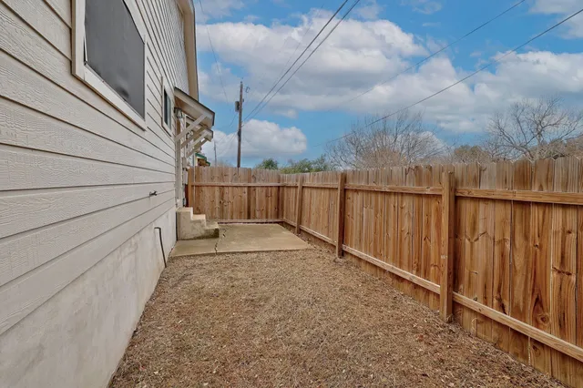 a view of backyard and wooden fence