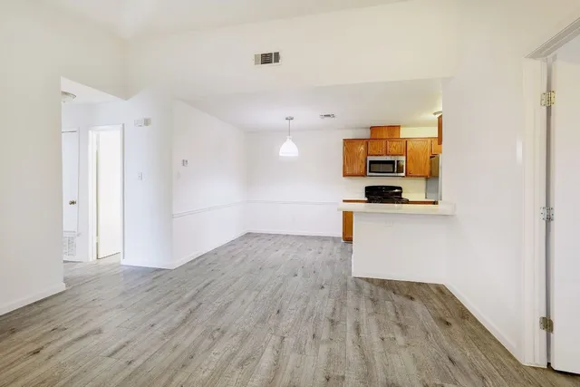 a view of empty room with wooden floor