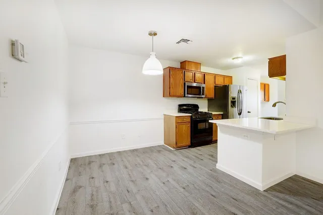a kitchen with stainless steel appliances granite countertop a stove and wooden floor
