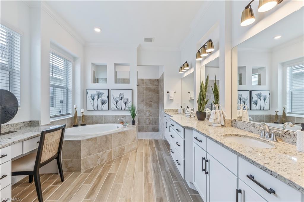 15977 Cranes Marsh Court Babcock Ranch, FL 33982 - Photo 14 of 24 a spacious bathroom with a granite countertop tub sink and mirror