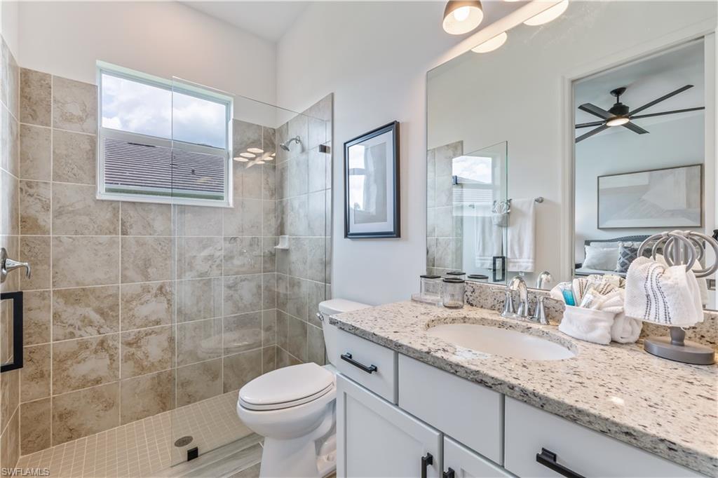 15977 Cranes Marsh Court Babcock Ranch, FL 33982 - Photo 18 of 24 a bathroom with a granite countertop toilet sink and mirror