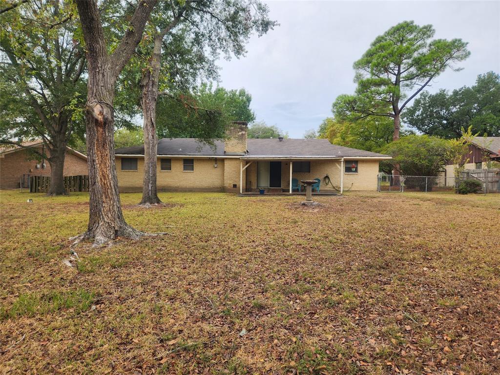 2821 Mccarley Drive Commerce, TX 75428 - Photo 5 of 32 a front view of a house with garden
