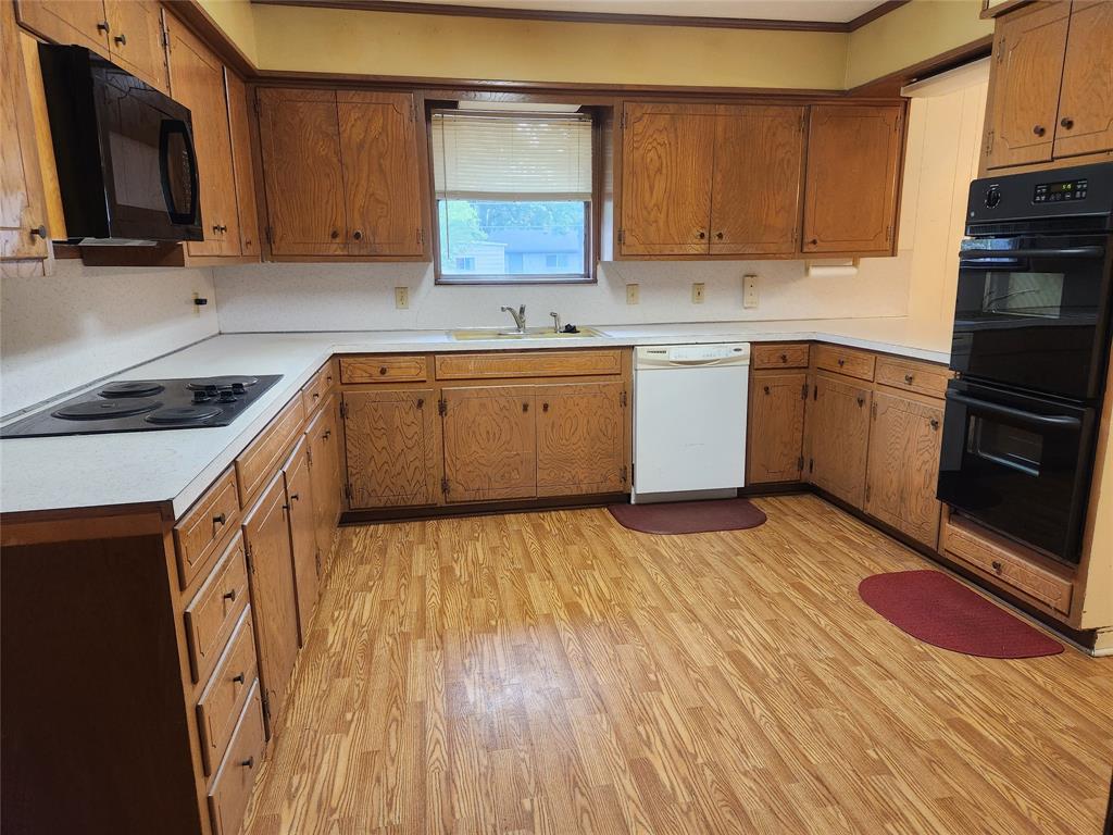 2821 Mccarley Drive Commerce, TX 75428 - Photo 8 of 32 a kitchen with a sink stove and cabinets