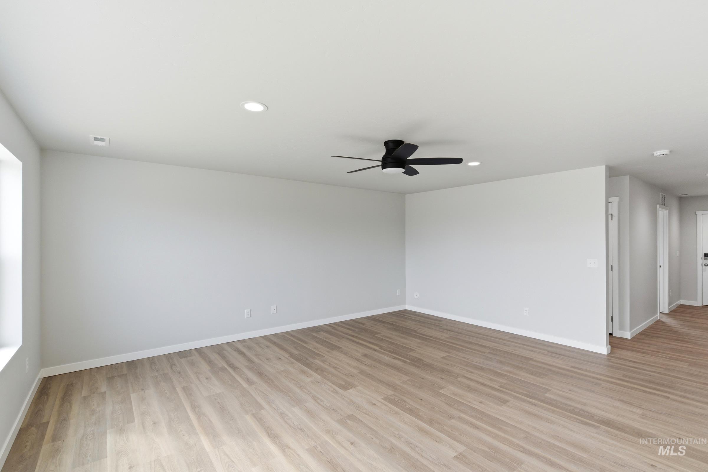 16558 Dunning Way Caldwell, ID 83607 - Photo 8 of 35 Spacious room featuring wood-finish flooring, recessed lighting, a modern ceiling fan, and crisp white trim
