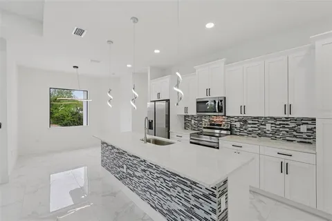 a kitchen with stainless steel appliances kitchen island granite countertop a sink and cabinets