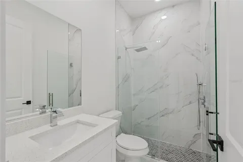 a bathroom with a sink a toilet and shower