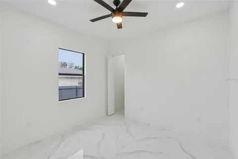 an empty room with shelves and fan