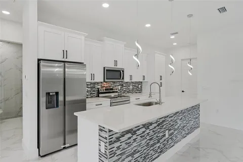 a kitchen with stainless steel appliances granite countertop a refrigerator and a sink
