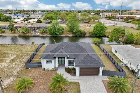 an aerial view of a house with a yard and lake view