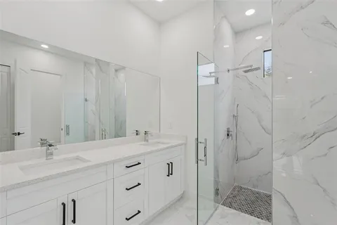a bathroom with a double vanity sink mirror and shower