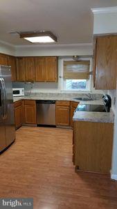 6249 Light Point Place Columbia, MD 21045 - Photo 7 of 18 a kitchen with stainless steel appliances granite countertop a sink counter space and wooden floor